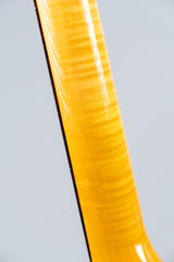 Close-up of a Knaggs Severn electric guitar flamed maple neck on a gray background