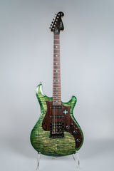 Green electric guitar Knaggs Severn on a stand against a gray background
