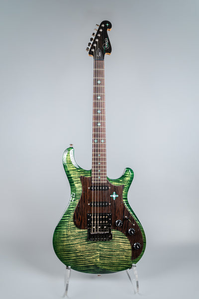 Green electric guitar Knaggs Severn on a stand against a gray background